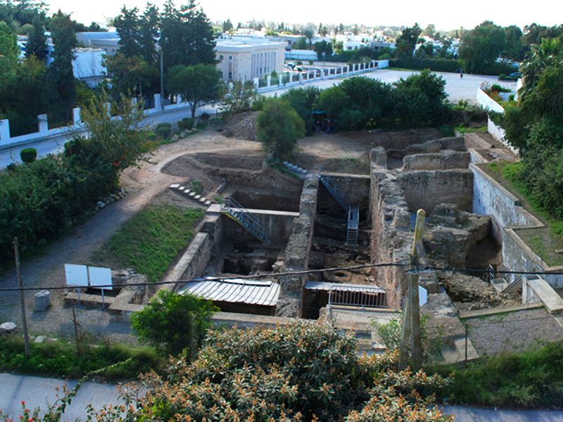 Karthago (Tunesien), Rue Ibn Chabâat. Grabungsgelände von Norden (2012). Im Schutz der römischen Mauern konnten 8 m unter heutigem Niveau die ältesten Belege für eine Besiedlung freigelegt werden